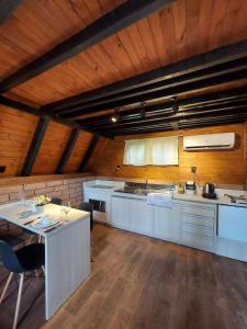 eine große Küche mit weißen Schränken und einer Holzdecke in der Unterkunft Mon Chalet in Praia Grande