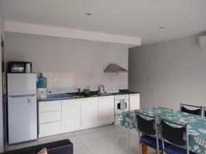 a kitchen with a table and a white refrigerator at Refugio Viajero in General Alvear