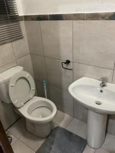 a bathroom with a toilet and a sink at KwaSihle Guesthouse in Dobsonville