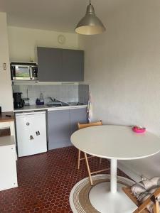 eine Küche mit einem weißen Tisch und einem weißen Tisch in der Unterkunft Un Cottage à la Mer in Le Pouliguen