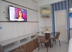 a room with a tv on a wall with a table at Pousada Bella Praia in Torres