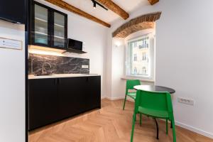 a kitchen with green chairs and a table at Corso Apartments in Rijeka