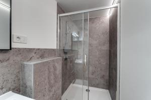 a shower with a glass door in a bathroom at Corso Apartments in Rijeka +48 photos