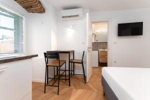 a bedroom with a bed and a table and two chairs at Corso Apartments in Rijeka