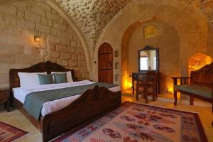 a bedroom with a large bed in a stone room at Aryan Butik Otel in Mardin