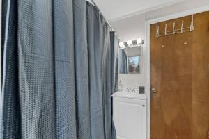 a bathroom with blue shower curtains and a toilet at Perfect Location and Fast Wi-Fi Heart of Village in Hamburg