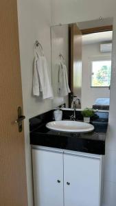 un baño con lavabo y espejo en Comfy apartment in the Preguiças riverfront, en Barreirinhas