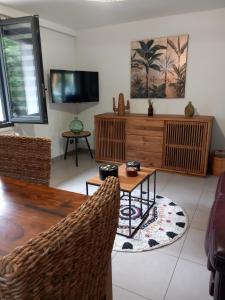 a living room with a tv and a table and chairs at Bella Loire in Le Monteil