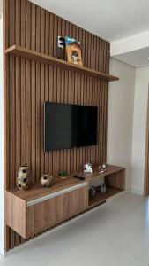 TV en la pared de madera de la sala de estar. en Comfy apartment in the Preguiças riverfront, en Barreirinhas