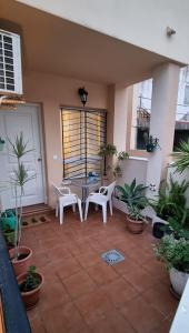 a patio with a table and chairs and plants at La casita de hercules in Algeciras