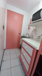 a red door in a kitchen with a red cabinet at STUDIO EM FORTALEZA NO CONDOMINIO VILA DE IRACEMA in Fortaleza