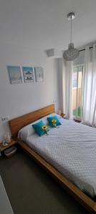 a bedroom with a large bed with blue pillows at La casita de hercules in Algeciras