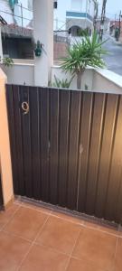 a black gate in a house with a palm tree at La casita de hercules in Algeciras +5 photos