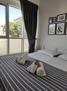 a bedroom with two towels on a bed with a window at Mamba House - 200 mt dal mare in Terracina
