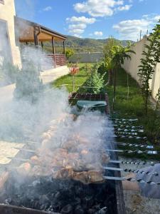 una parrilla de barbacoa con humo saliendo de ella en River Side Villa, en Dushetʼi
