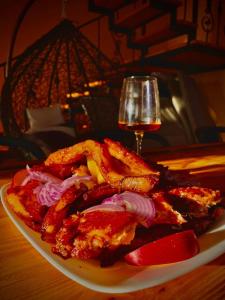 Un plato de comida en una mesa con una copa de vino. en River Side Villa, en Dushetʼi