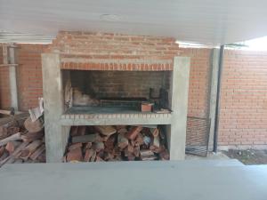 a brick fireplace with a pile of fire wood at La casita de duggan in Duggan