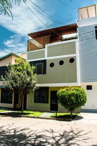 a white building with a tree in front of it at Del Valle House in Ica
