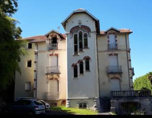 a building with a car parked in front of it at Résidence Le Tuc Saint Jean in Dax
