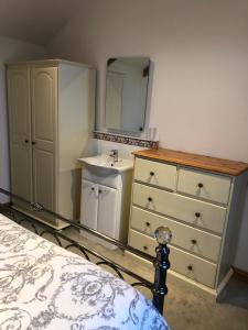 a bedroom with a sink and a dresser with a mirror at The Nook in Padstow +30 photos