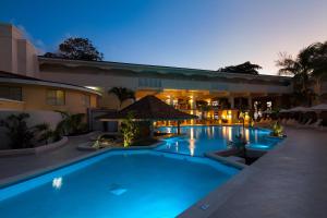 a swimming pool in front of a building at night at Sugar Bay Barbados - All Inclusive in Bridgetown