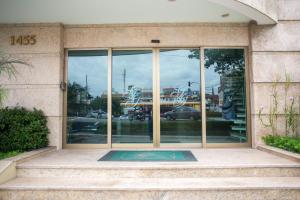 an entrance to a building with glass windows at Gloria Garden Suites in Macaé