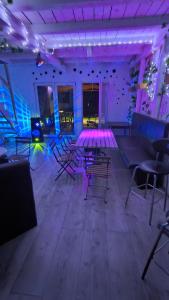 a room with chairs and tables and purple lights at ZAPPA na savi in Pe°ani