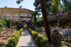 a garden with a table and chairs and a vase at Anthea Butik Otel in Adalar