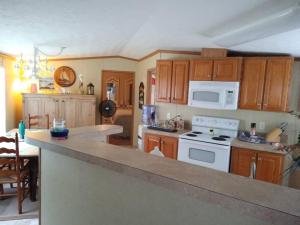 a kitchen with wooden cabinets and a white stove top oven at SummerTime, Pleasures in Cape Carteret