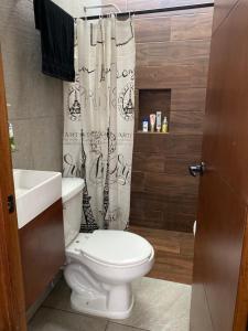 a bathroom with a toilet and a shower curtain at Casa Fer Para 8 Personas Cerca de playa San Blas in Tepic +46 photos
