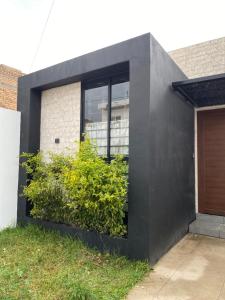 a black house with a window and a bush at Casa Fer Para 8 Personas Cerca de playa San Blas in Tepic