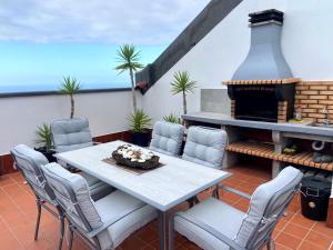 a patio with a table and chairs and a fireplace at Apartamentos Los Verodes in Frontera