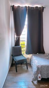 a bedroom with a chair in front of a window at Casa Fer Para 8 Personas Cerca de playa San Blas in Tepic