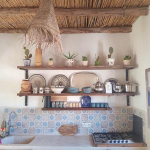 a kitchen with wooden shelves above a sink at Moroccan Boho Surf House in Agadir