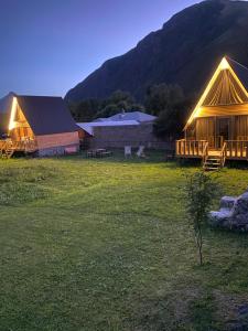 a group of lodges in a field at night at Sunny side cottage in Kazbegi