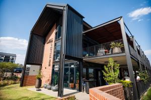 a house with a black facade with a balcony at K47 propertyzz in Midrand