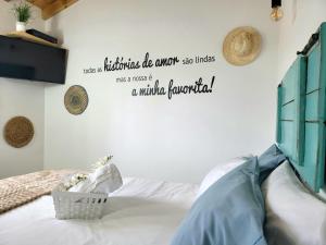 a bedroom with a bed with a quote on the wall at Casinha da Esquina - Refúgio Alentejano a 700m da Praia in Amieira