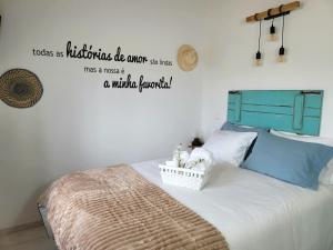 a bedroom with a bed with a sign on the wall at Casinha da Esquina - Refúgio Alentejano a 700m da Praia in Amieira
