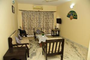 ein Wohnzimmer mit Stühlen, einer Couch und einem Tisch in der Unterkunft Coconut Grove Holiday Apartment in Varca