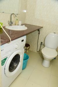 ein Badezimmer mit Waschmaschine und Waschbecken in der Unterkunft Coconut Grove Holiday Apartment in Varca
