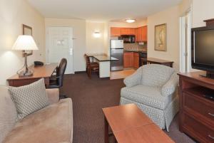 a living room with a couch and chairs and a kitchen at Staybridge Suites Rocklin - Roseville Area, an IHG Hotel in Rocklin