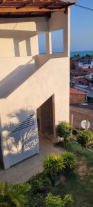 un edificio blanco con garaje con puerta en Maragogi Hostel, en Maragogi