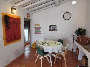 a dining room with a table and chairs and a clock at Casa da Chaminé - A Casa da Chaminé "torta" in Amieira