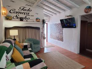 a living room with a couch and a tv on a wall at Casa da Chaminé - A Casa da Chaminé "torta" in Amieira