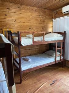 una stanza con due letti a castello in una cabina di Pousada Casa de Madeira a Porto De Galinhas