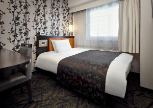 a hotel room with a bed and a desk and a window at APA Hotel Saitama Higashimatsuyama Ekimae in Higashimatsuyama