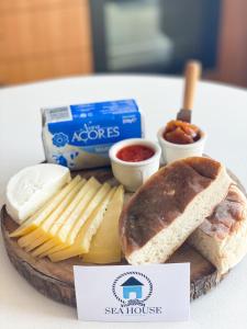 a plate of food with cheese and bread and dips at Sea House in Povoação