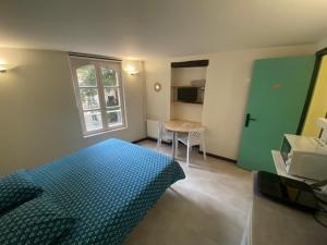 Un dormitorio con una cama azul y una mesa. en Appartement ou chambre centre cherbourg, en Cherbourg-en-Cotentin