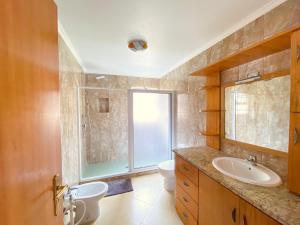 a bathroom with a sink and a toilet and a window at Sea House in Povoação