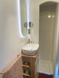 a bathroom with a white sink and a tub at Charming cocon, well-located Apartment 2 rooms in Malakoff